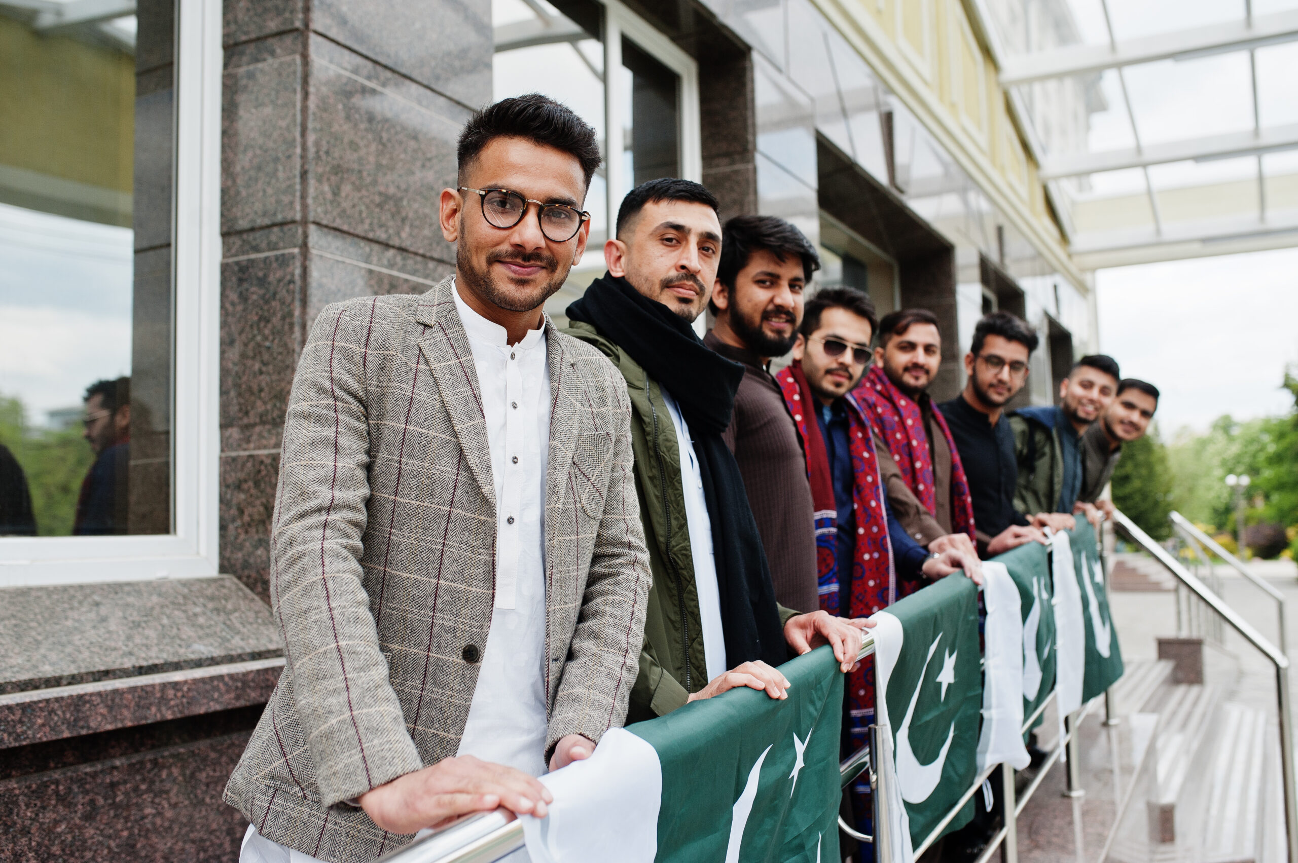Group of pakistani man wearing traditional clothes salwar kameez or kurta with Pakistan flags.